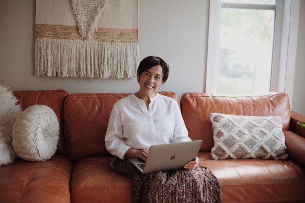 A businesswoman that Double Iron Consulting can help sits at her computer and smiles