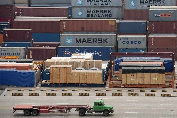 A truck drives past Maersk and Cosco con
