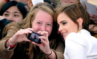 Actress Emma Watson poses with fans