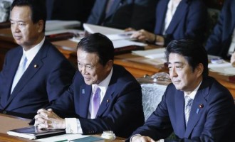 Japan's Prime Minister Shinzo Abe (R) sits with Japan's Deputy Prime Minister and Finance Minister Taro Aso (C) and Japan's Economics Minister Akira Amari