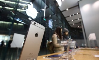 Customer try out an Apple Inc. iPhone 6 at an Apple store in the China Central Mall in Beijing, China, on Tuesday, Nov. 11, 2014. Apple, which ended the fiscal fourth quarter with $155.2 billion in cash, is forecasting a record holiday sales quarter after