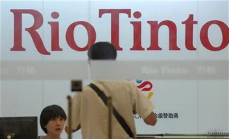 An employee talks to a visitor at the reception desk of the Rio Tinto Limited Shanghai Representative Office in Shanghai August 5, 2010. REUTERS/Stringer