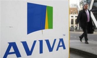 A man walks past an AVIVA logo outside the company's head office in the city of London March 5, 2009. REUTERS/Stephen Hird